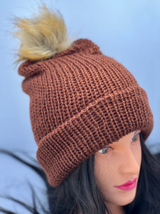 Dark brown knitted beanie with faux fur pom-pom