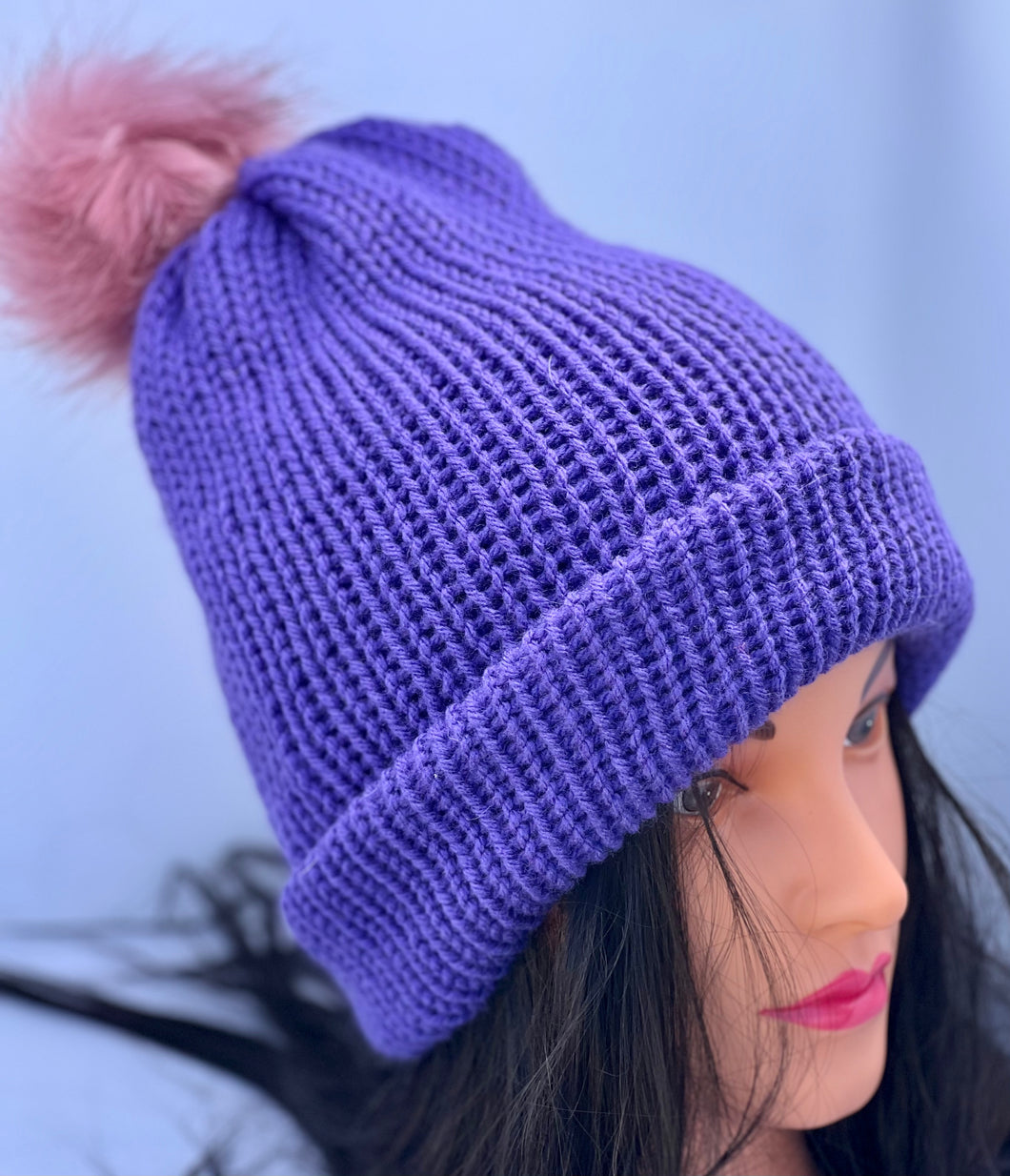 Solid dark purple knitted beanie with faux fur pom-pom