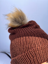 Dark brown knitted beanie with faux fur pom-pom