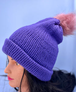 Solid dark purple knitted beanie with faux fur pom-pom