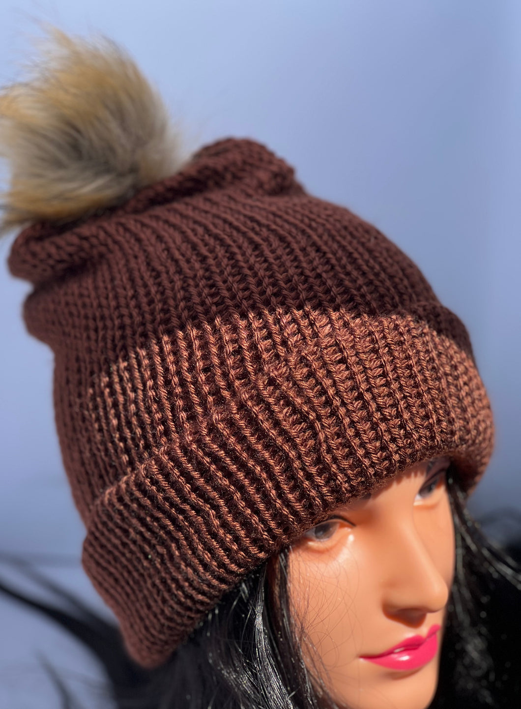 Dark brown knitted beanie with faux fur pom-pom